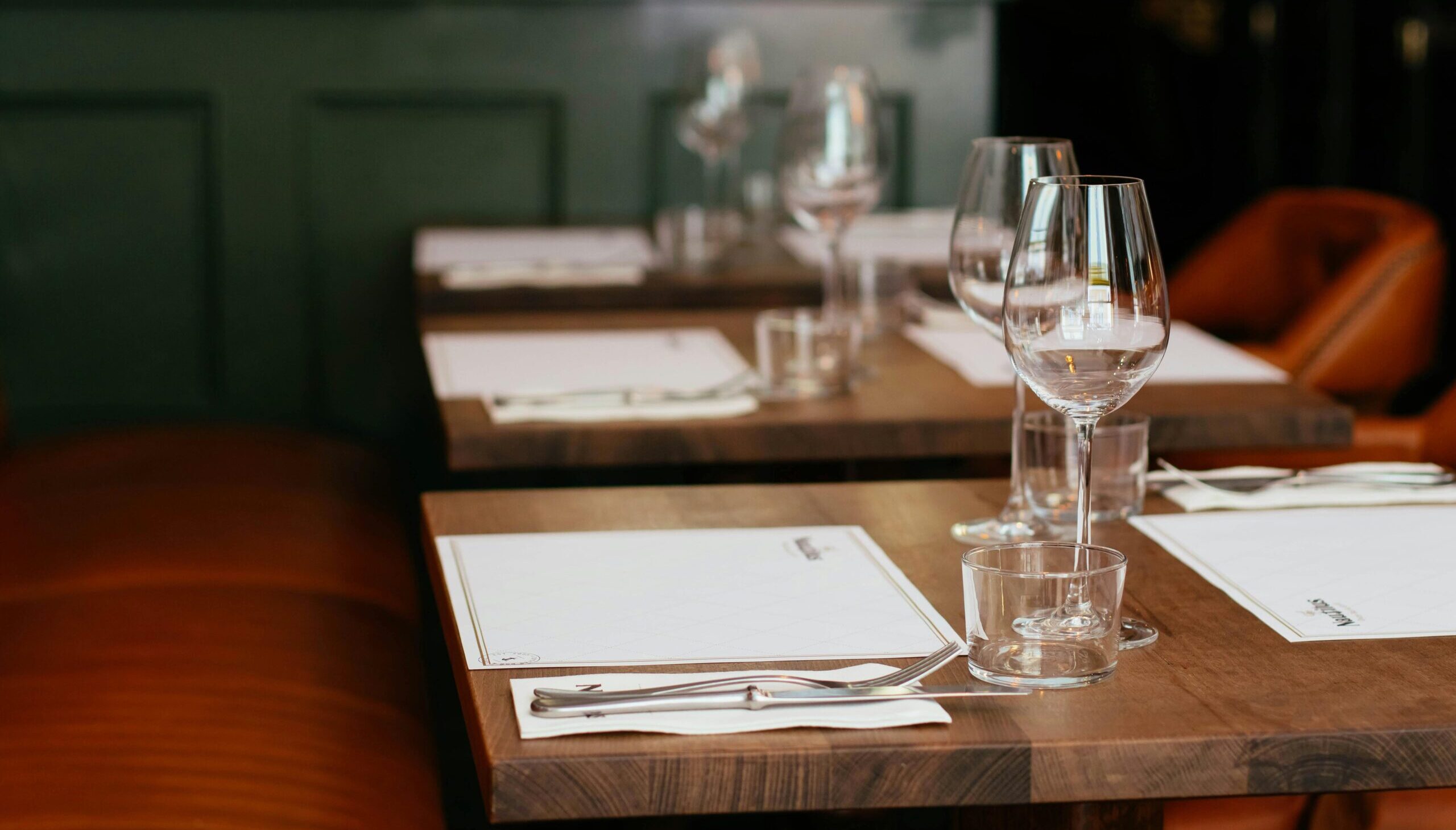 Chic restaurant table setting complete with cutlery and crystal wine glasses for an upscale dining experience.